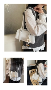 Detailed view of white PU leather baguette bag with flower charm and adjustable strap