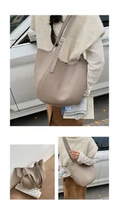 Detail of taupe pebbled leather tote bag with silver metal buckle and soft texture