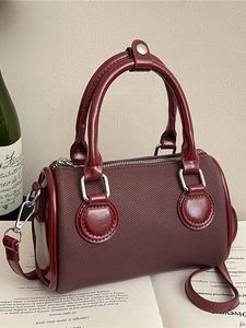 Fashionable wine red Boston handbag with glossy leather details and silver metal hardware