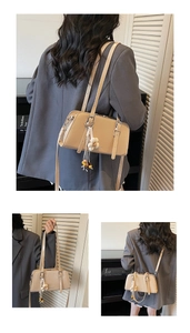 Detail of beige tote with floral pendant and adjustable shoulder straps in modern interior