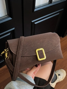 Dark brown textured leather crossbody bag with elegant gold metal buckle closure