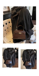 Dettaglio della borsa a tracolla vintage marrone scuro con fibbia dorata e forma a trapezio