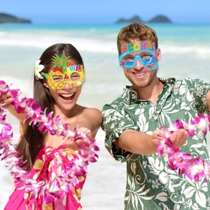 Hawaiian party photo props set with pineapple and aloha themed paper glasses on beach