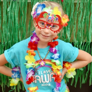 Hawaiian party set with crab glasses and colorful floral leis on green backdrop