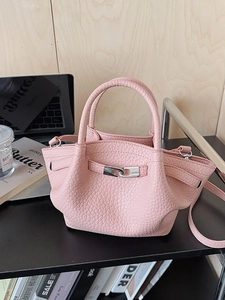 Minimalist pink pebble leather bucket bag with silver buckle and cross-body strap