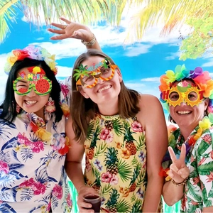 Three models wearing pineapple, palm tree, and summer sun paper glasses for Hawaiian parties