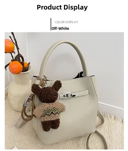Détail du sac seau beige en cuir PU grainé avec un charmant pendentif d'ours marron