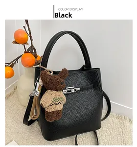 Détail du sac seau en cuir grainé noir avec fermoir argenté et petit ours en peluche