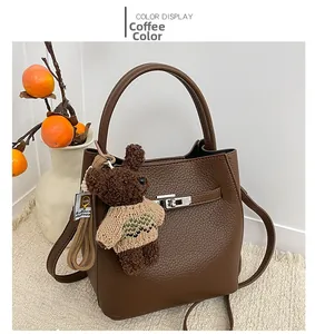 Détail d'un sac seau en cuir grainé café avec charm ours et boucle métallique robuste