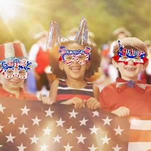 Drie kinderen dragen USA-themafeestbrillen voor 4 juli in een zonnig park buiten