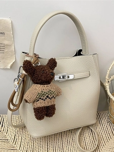 Sac seau minimaliste beige avec texture litchi et charmant pendentif d'ours en peluche