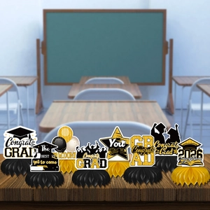 Detail of Class of 2026 graduation honeycomb centerpieces set in black and gold on a desk