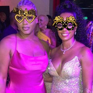 Women wearing festive 40th birthday and 1986 year themed party glasses with glitter accents
