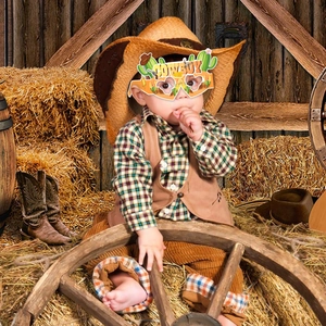 Kid model wearing Western cowboy paper glasses with cactus and pistol patterns in a barn