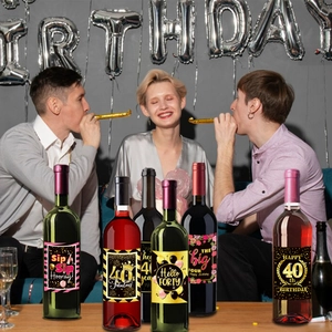 Close-up of elegant black and gold 40th birthday wine bottle labels for party decor