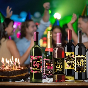 Five assorted black and gold 40th birthday wine bottle labels with party decorations