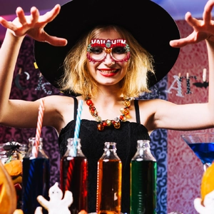 Detail of Halloween party glasses with spooky pumpkin and zombie hand on a model