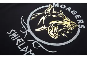 Gros plan de l'imprimé graphique tête de chien doré et argenté sur un t-shirt noir