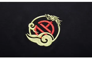 Close-up of golden dragon embroidery with red Chinese motif on black cotton fabric