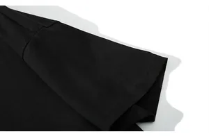 Dettaglio della cucitura a doppio ago sulle maniche della T-shirt nera e trama del tessuto