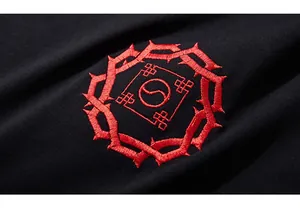 Macro detail of red circular dragon and yin-yang embroidery on black cotton t-shirt