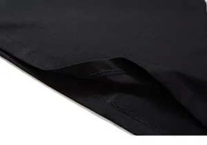 Close-up of double-stitched hem and fine knit texture on a black oversized t-shirt