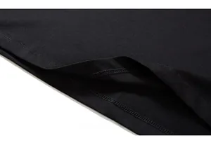 Close-up of premium double-needle hem stitching on a black cotton oversized t-shirt