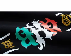 Close-up of flame-patterned B letter print with gold glitter on black hoodie fabric
