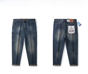 Flat lay of vintage washed blue straight-leg jeans featuring whiskers and leather patch