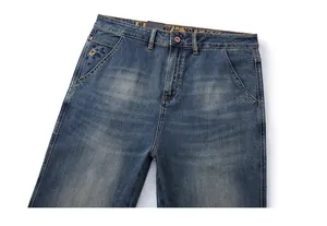Detail of vintage washed blue jeans featuring reinforced stitching and geometric embroidery