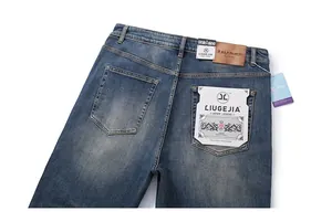 Close-up of vintage washed denim jeans featuring leather patch and YKK zipper detail
