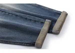Macro shot of cuffed hem on vintage washed blue jeans showing double stitching and texture