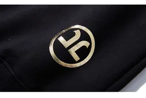 Détail macro du logo doré imprimé sur un tissu en coton tricoté noir de haute densité