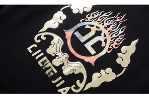 Makrodetail des Grafikdrucks mit goldenen Wolkenmustern auf schwarzem Sweatshirt-Stoff