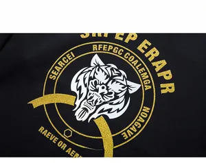 Macro view of a black hoodie featuring golden glitter tiger head print and circular text