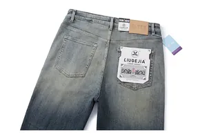 Detail view of washed denim jeans back pockets with leather patch and branded tags