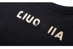 Detailansicht des goldenen Siebdrucks auf schwarzem Stoff für Oversized-Sweatshirts