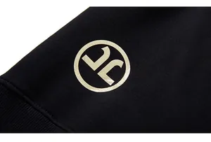 Detail der Rippbündchen am schwarzen Sweatshirt mit metallischem Rundlogo-Aufdruck