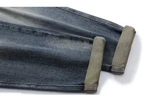Detailed macro view of vintage washed denim cuffs with yellow-green lining and stitching