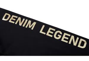 Détail de l'imprimé doré Denim Legend sur la manche d'un sweat-shirt noir surdimensionné