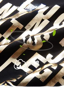 Détail du tissu en jersey de coton noir avec imprimés de lettres en feuille d'or