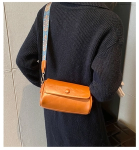 Dettaglio della borsa a cilindro marrone con tracolla larga a motivi geometrici colorati