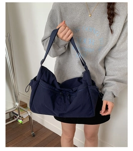 Detail of navy blue large capacity tote with functional zipper and drawstring pockets
