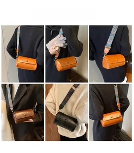 Dettaglio borsa a cilindro con ampia tracolla in stile etnico e fibbia metallica decorativa