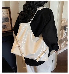 Gros plan du sac cabas blanc brillant avec boucle, porté par un mannequin en studio