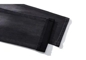 Close-up of rolled hem and precision stitching on vintage black denim trousers