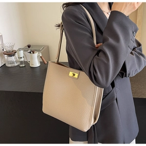 Dettaglio della borsa tote in pelle martellata con fibbia rotante in metallo dorato