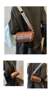 Dettaglio di borsa a cilindro marrone con tracolla larga in stile etnico blu e arancio