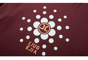 Detail of burgundy cotton T-shirt featuring white polka dot sun flower print and logo