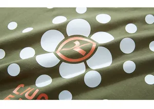 Macro view showing olive green knit fabric texture with white floral and orange prints